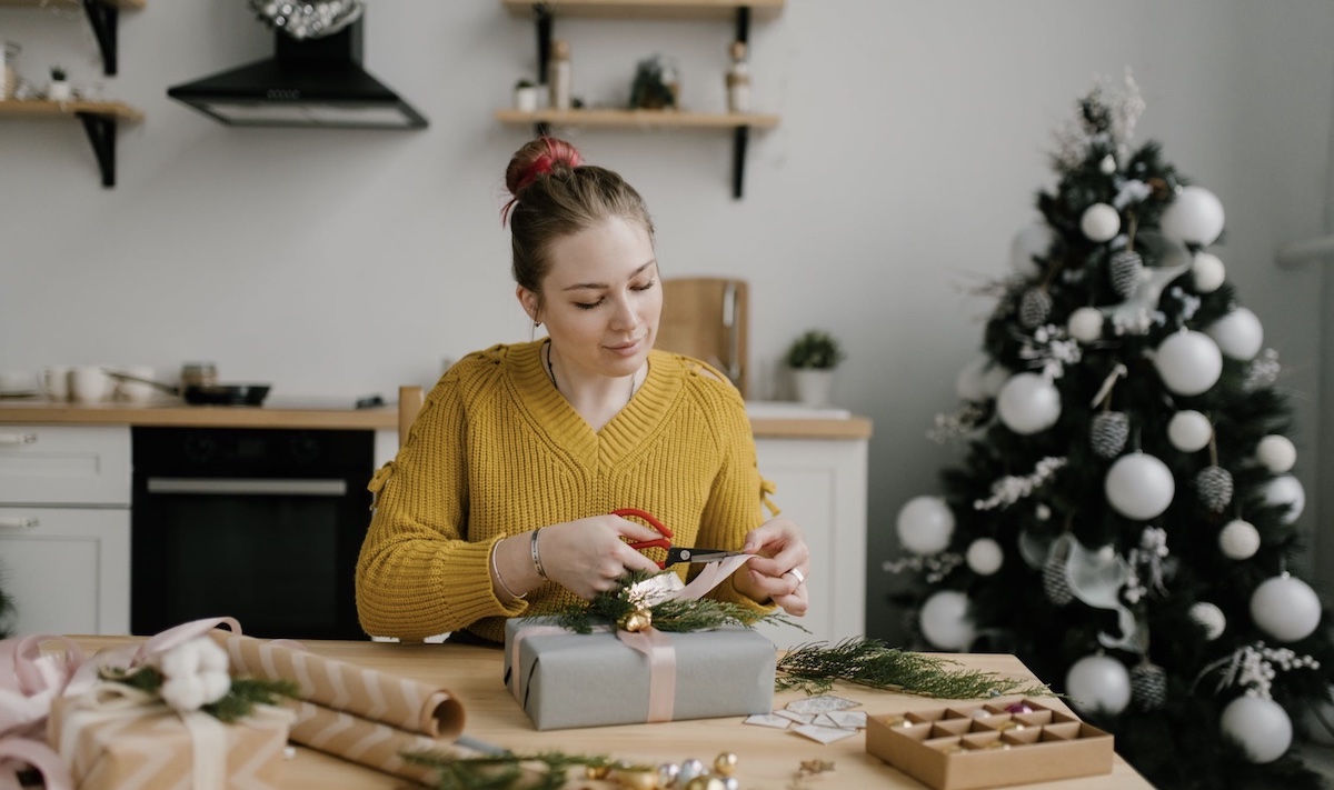 Woman wrapping presents during holiday season. Image: Pexels - Julia Volk