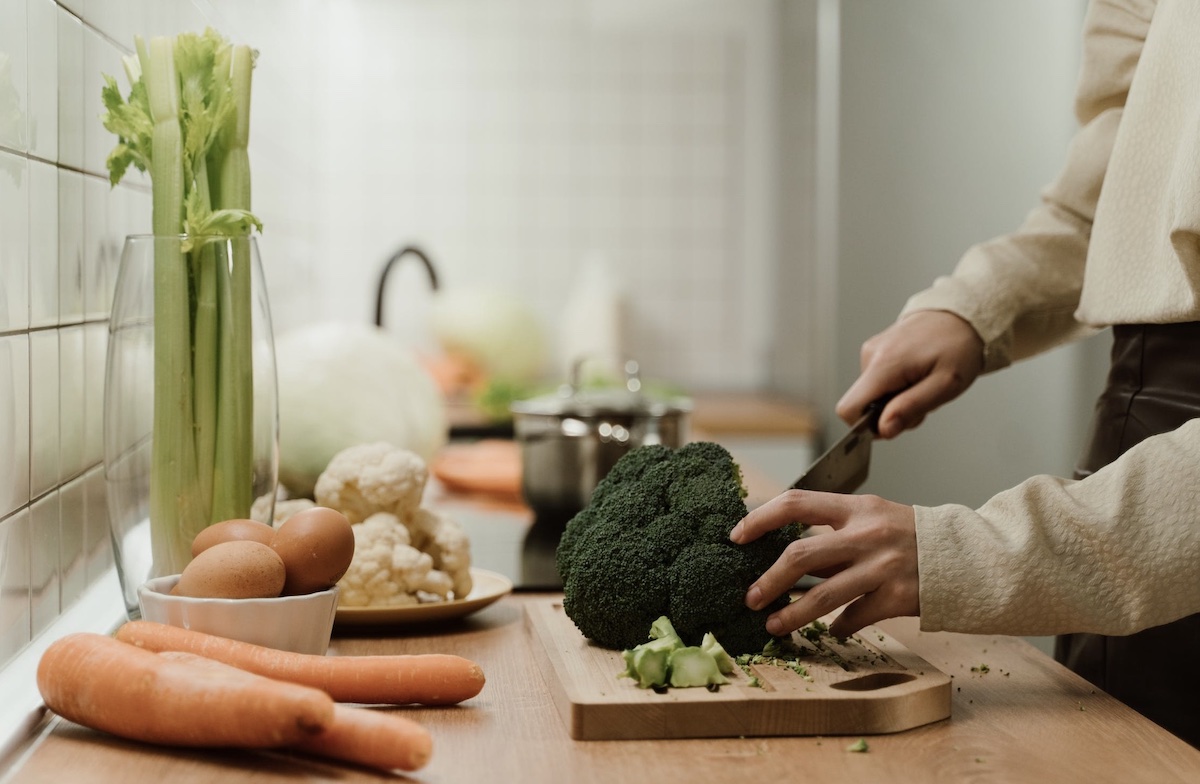 Woman cutting vegetables. Image: Pexels - Ron Lach