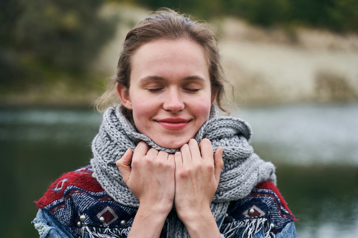 Women self-reflecting by a lake