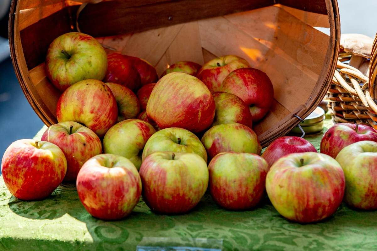 Apples rolling out of a box on a table