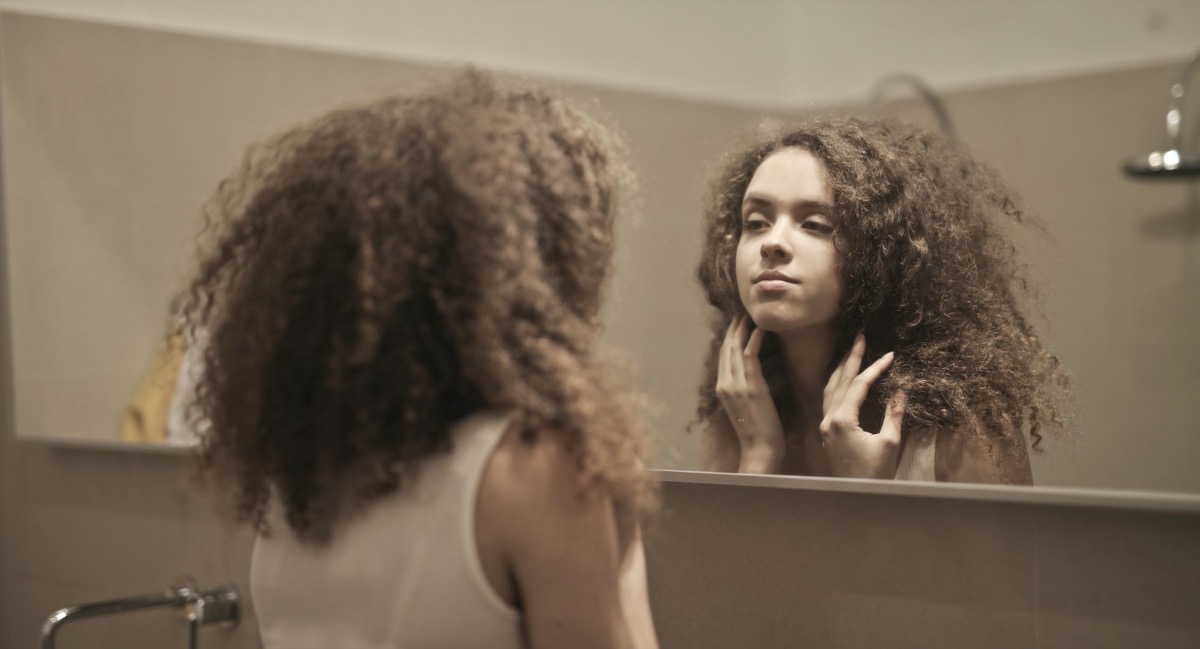 Female looking into the mirror. Image: Pexels - Andrea Piacquadio