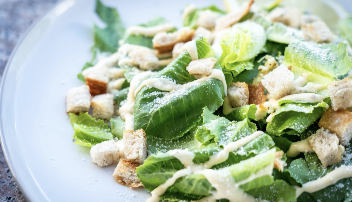 Caesar salad with croutons and dressing. Unsplash- Chris A. Tweten