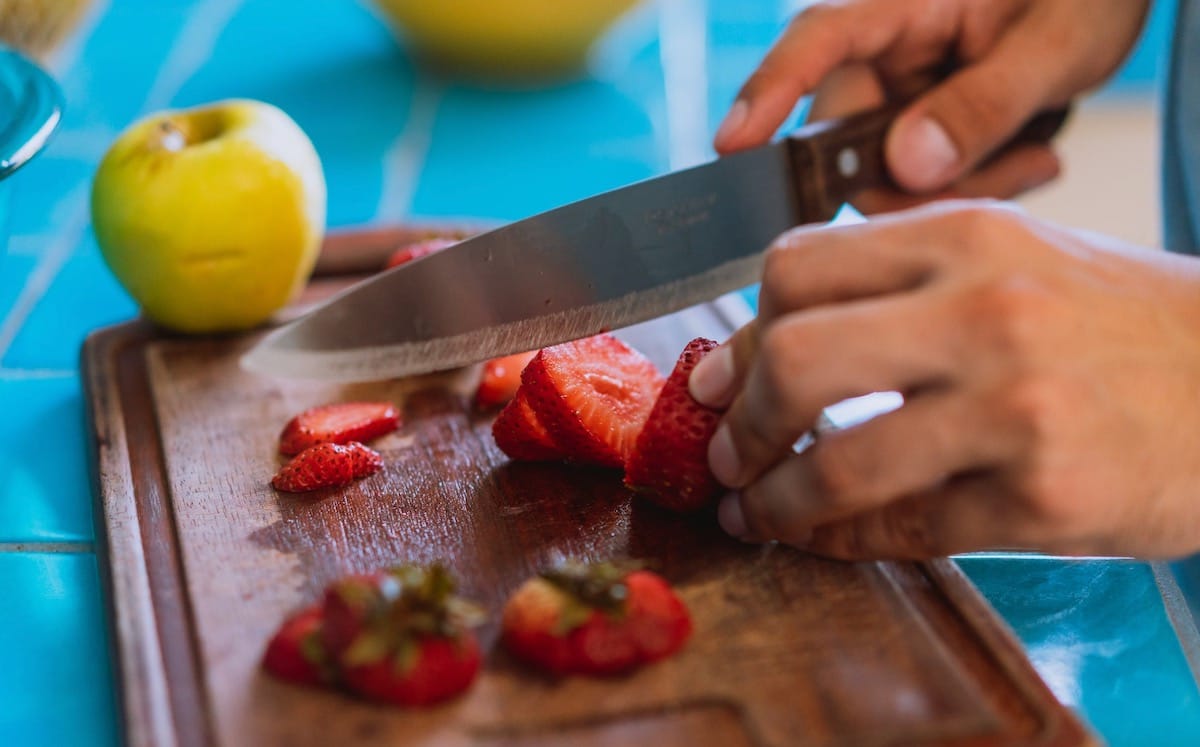 Cutting up strawberries on cutting board